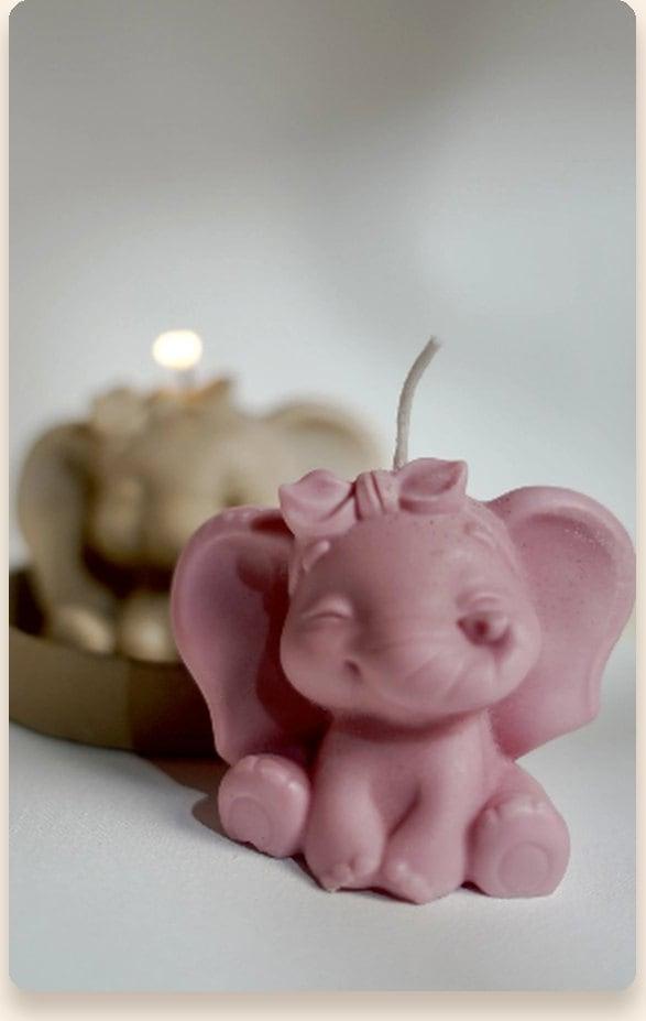 Pink hand-poured baby elephant candle wearing a bow